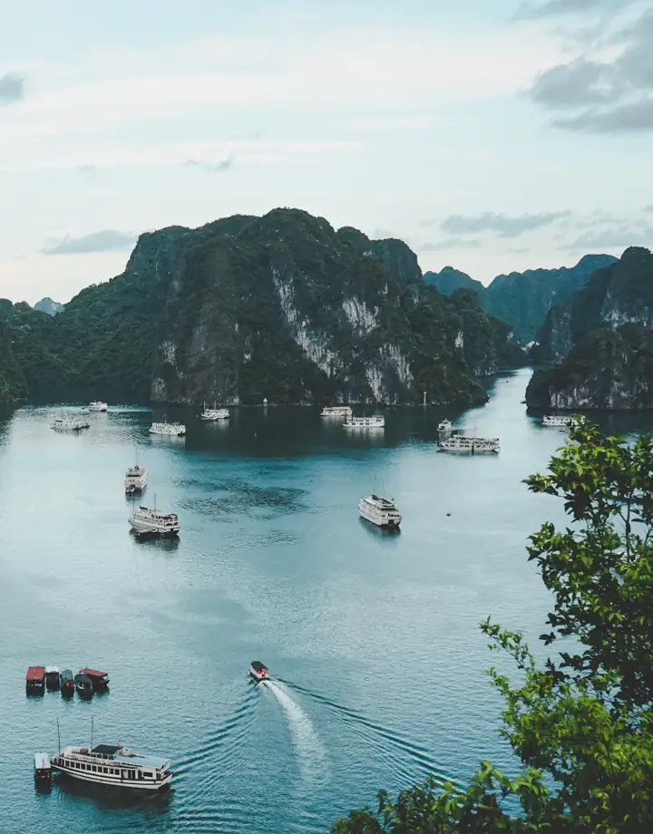 Baía com formações rochosas e barcos tradicionais