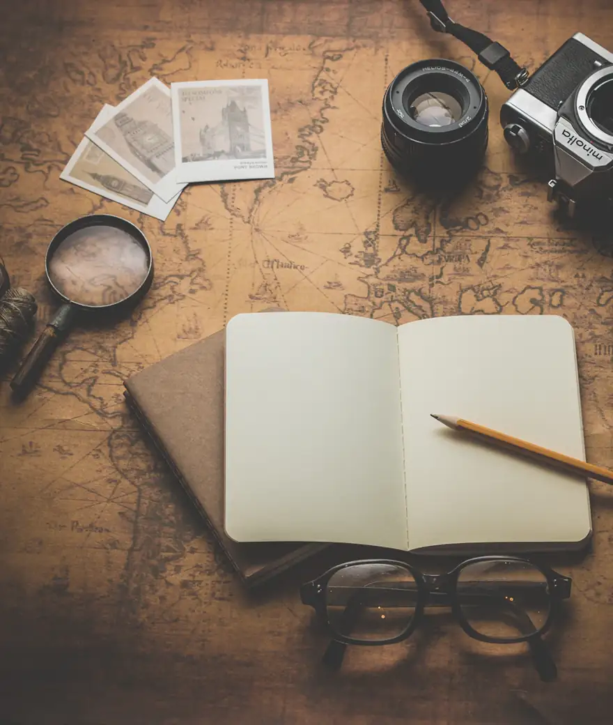 Mapa, câmera e caderno de planejamento de viagem